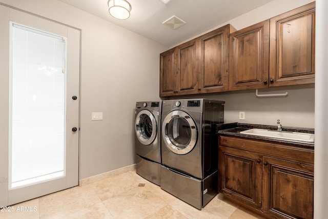 clothes washing area with cabinets, sink, and independent washer and dryer