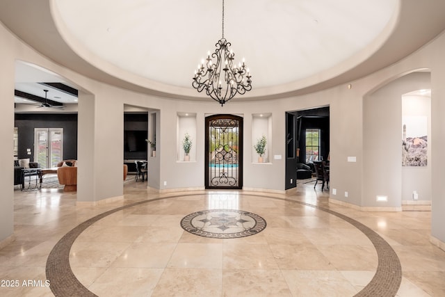 foyer with plenty of natural light and ceiling fan with notable chandelier