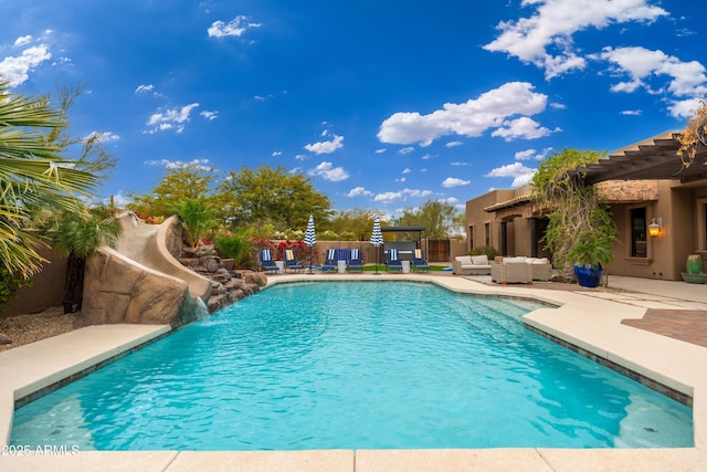 view of swimming pool featuring pool water feature, outdoor lounge area, a pergola, and a patio