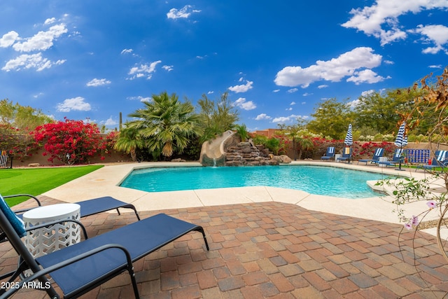 view of swimming pool featuring a water slide and a patio