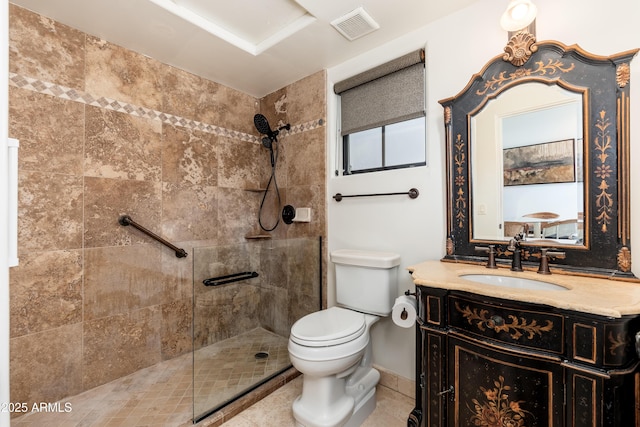 bathroom with vanity, tiled shower, tile patterned floors, and toilet