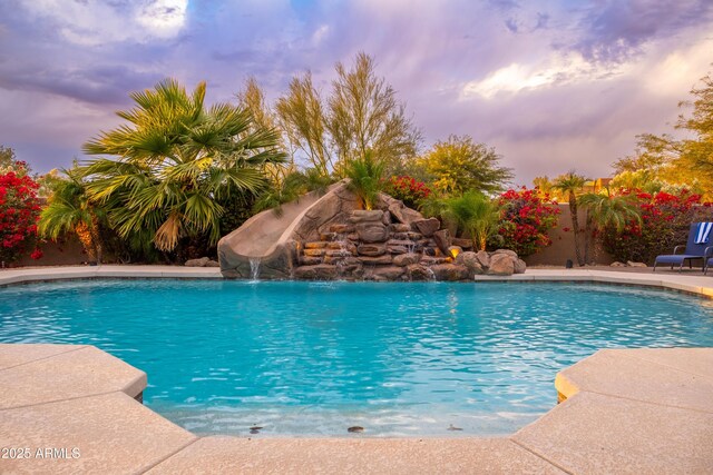 pool at dusk with pool water feature