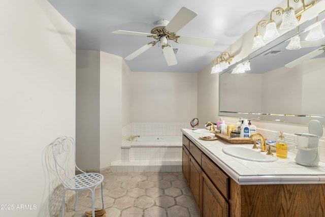 bathroom with a relaxing tiled tub, ceiling fan, vanity, and tile patterned flooring