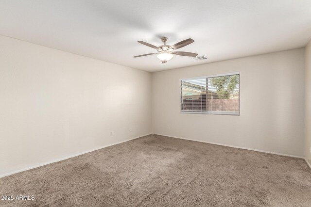 carpeted empty room with visible vents and a ceiling fan