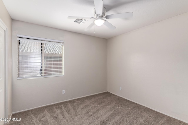 carpeted empty room with visible vents and a ceiling fan