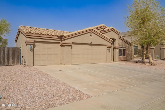 view of front of property featuring a garage, driveway, a tiled roof, and stucco siding