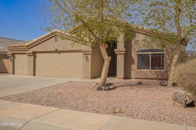 view of front of home featuring a garage, concrete driveway, a tiled roof, and stucco siding