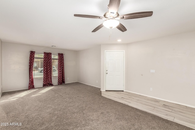 empty room with ceiling fan, carpet floors, and baseboards