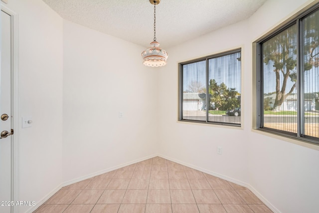 tiled spare room with a textured ceiling