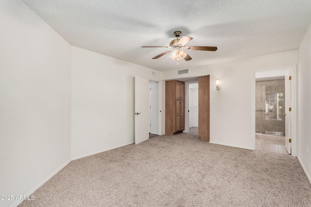 spare room featuring ceiling fan, light carpet, and a textured ceiling