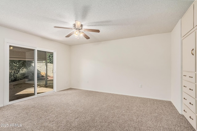 empty room featuring a textured ceiling, ceiling fan, and carpet flooring