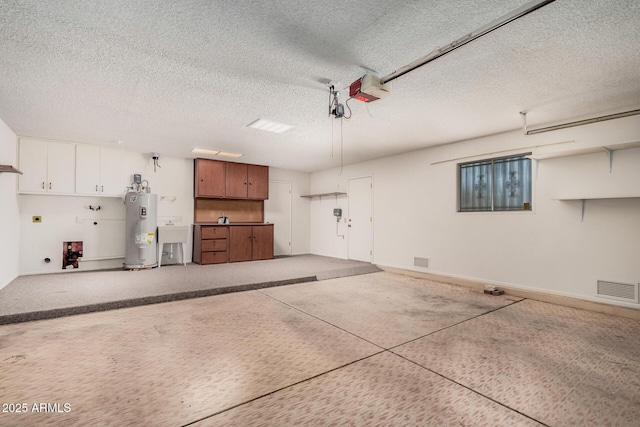 garage with a garage door opener, electric water heater, and sink