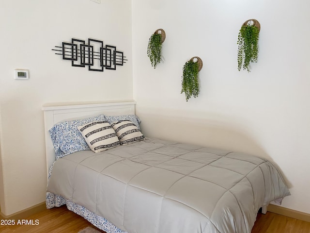 bedroom with wood finished floors and baseboards