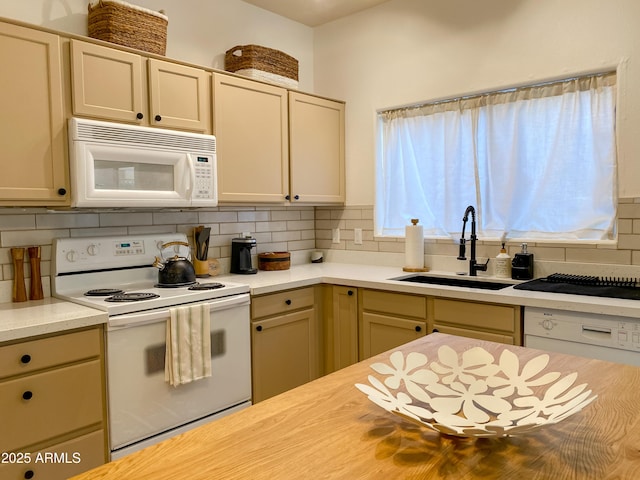 kitchen featuring tasteful backsplash, white appliances, light countertops, and a sink