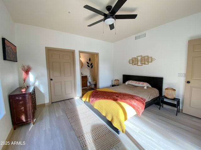 bedroom with baseboards, visible vents, connected bathroom, ceiling fan, and light wood-type flooring