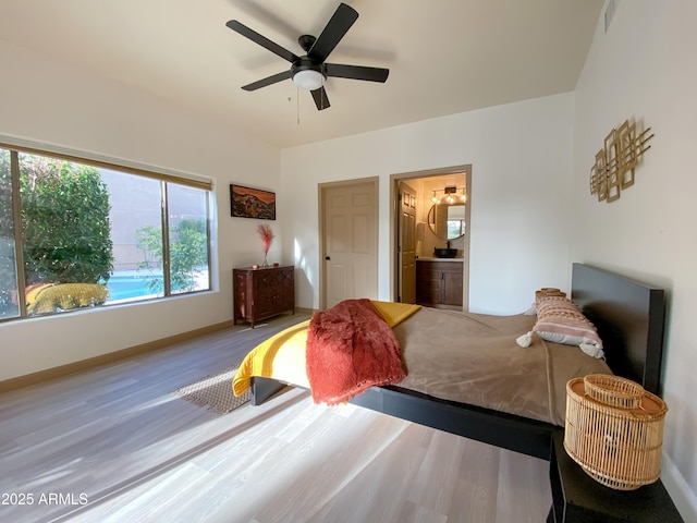 bedroom with visible vents, connected bathroom, baseboards, and wood finished floors