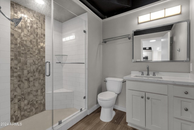 bathroom featuring hardwood / wood-style flooring, vanity, toilet, and a shower with door