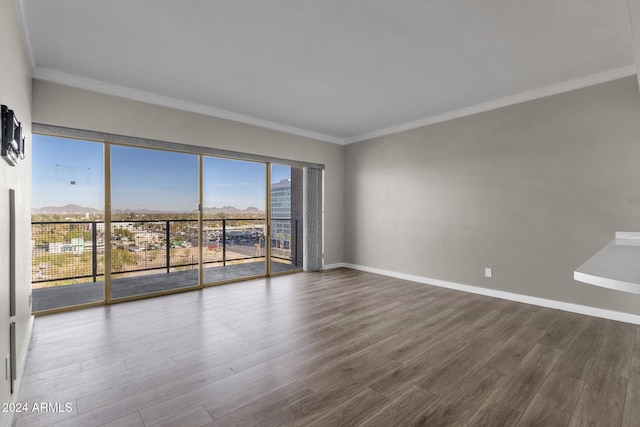 spare room featuring wood-type flooring and ornamental molding