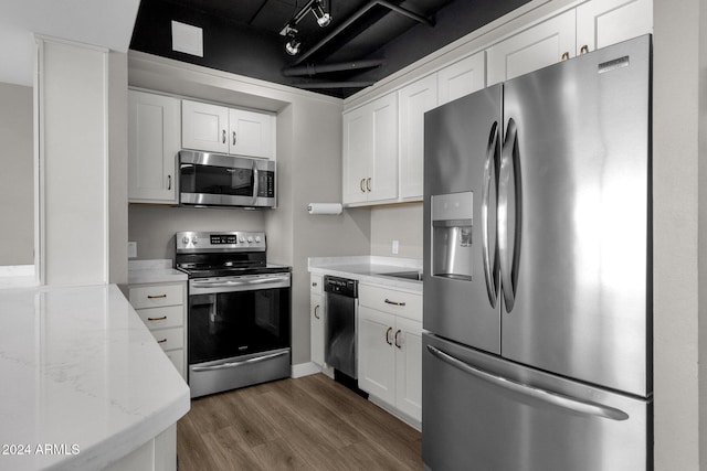 kitchen with white cabinetry, dark hardwood / wood-style flooring, light stone countertops, and appliances with stainless steel finishes