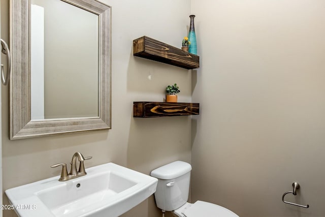 half bathroom featuring a sink and toilet