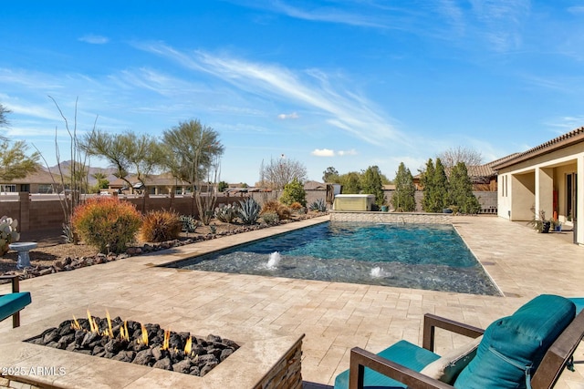 view of swimming pool with a fenced backyard, a fire pit, a pool, and a patio