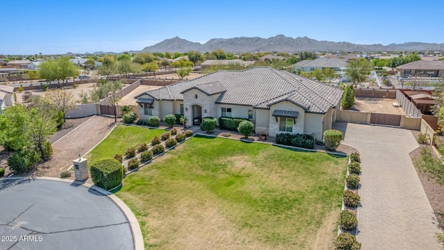 single story home with a front yard, a tiled roof, fence, stucco siding, and driveway