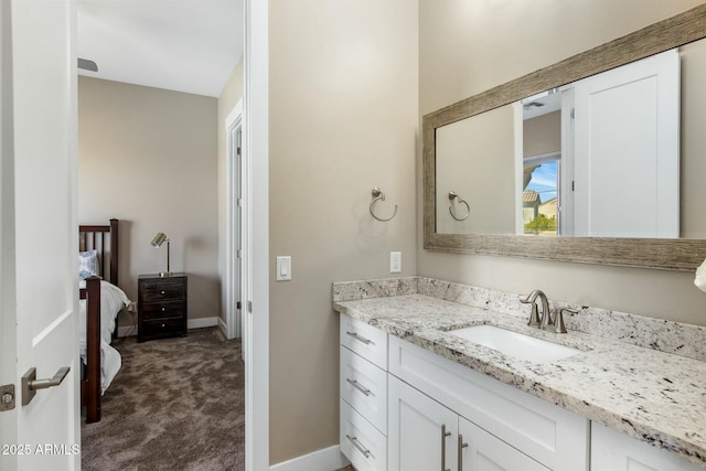 bathroom featuring vanity, baseboards, and ensuite bathroom