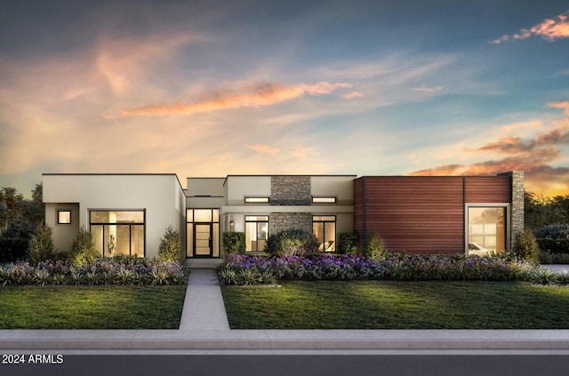 contemporary house featuring stucco siding, stone siding, and a front yard