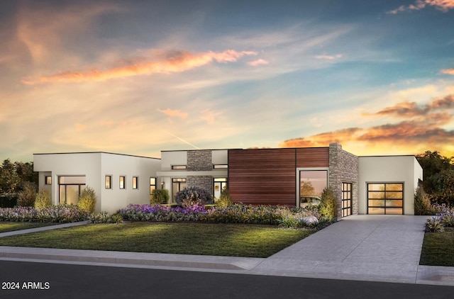 view of front of home featuring an attached garage, stucco siding, concrete driveway, and a front yard