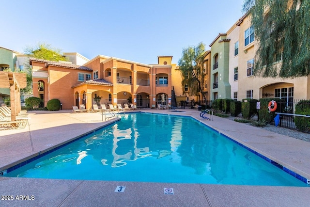 community pool featuring a patio area and fence