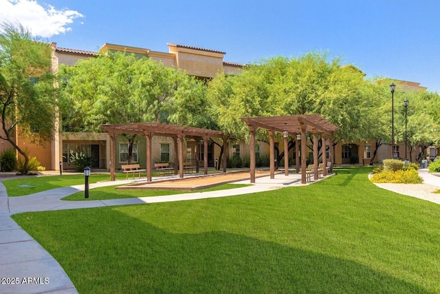 view of property's community featuring a yard and a pergola