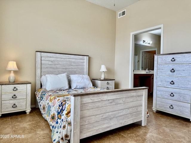 bedroom featuring dark tile patterned flooring, connected bathroom, and visible vents