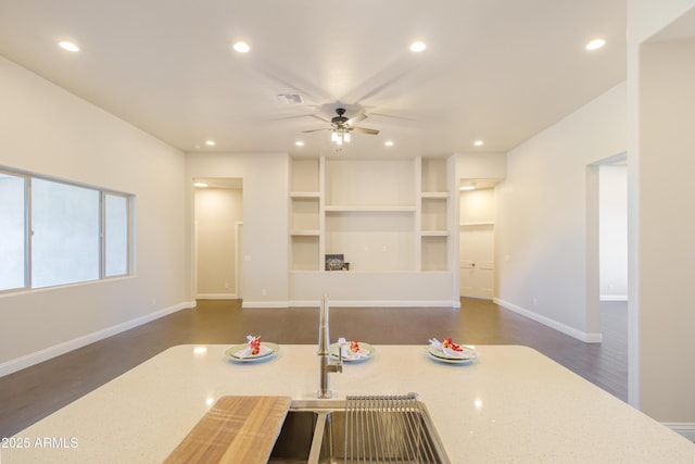 kitchen with ceiling fan, dark hardwood / wood-style flooring, and light stone countertops