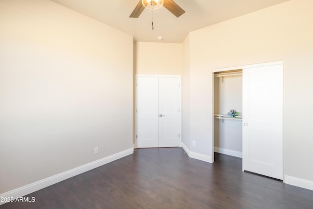 unfurnished bedroom featuring dark hardwood / wood-style floors, ceiling fan, and a closet