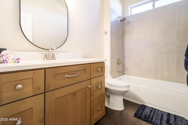 full bathroom with vanity, toilet, tiled shower / bath combo, and hardwood / wood-style floors