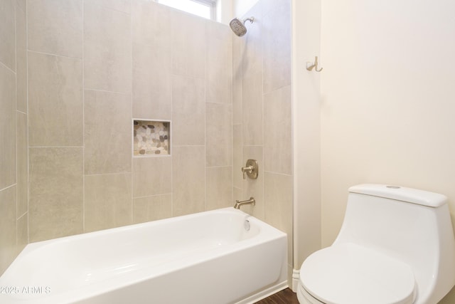 bathroom featuring tiled shower / bath and toilet