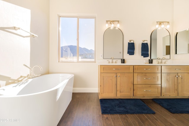 bathroom with vanity, a mountain view, hardwood / wood-style flooring, and a bathtub