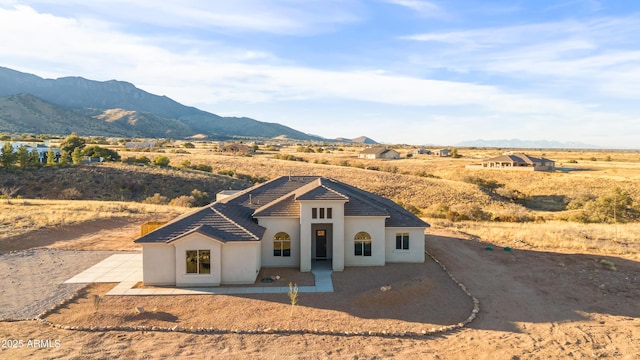 view of front of home with a mountain view and a patio