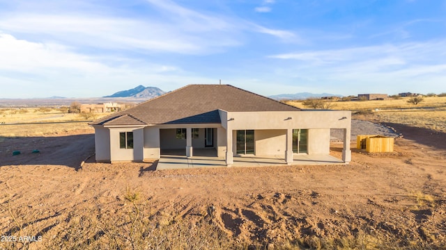 rear view of property featuring a mountain view and a patio area