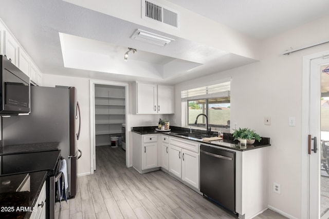 19031 N 13th Dr, Phoenix, AZ 85027 - kitchen featuring appliances with stainless steel finishes, a tray ceiling, a sink, dark countertops, and white cabinetry