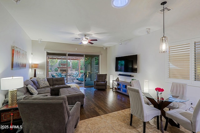 living room featuring visible vents, tile patterned floors, and a ceiling fan