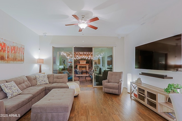 living room featuring wood finished floors and ceiling fan with notable chandelier