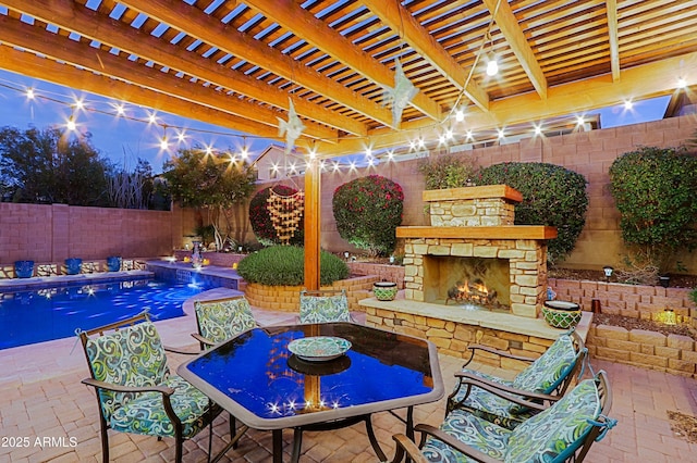 view of pool featuring an outdoor stone fireplace, a fenced backyard, outdoor dining space, and a patio area