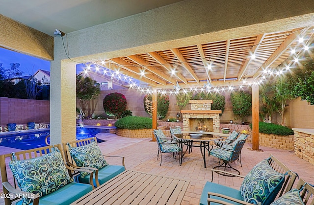 view of patio / terrace with a fenced backyard, outdoor dining space, an outdoor stone fireplace, and a fenced in pool