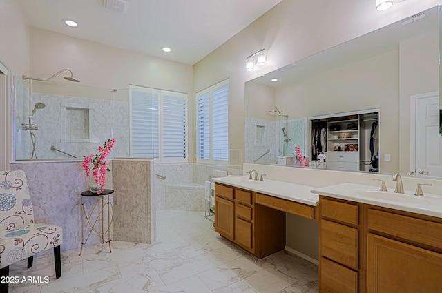 full bath with double vanity, visible vents, a sink, and a walk in shower