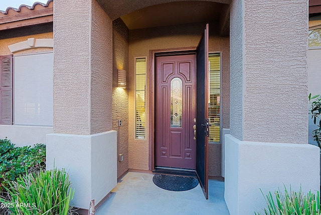 doorway to property featuring stucco siding