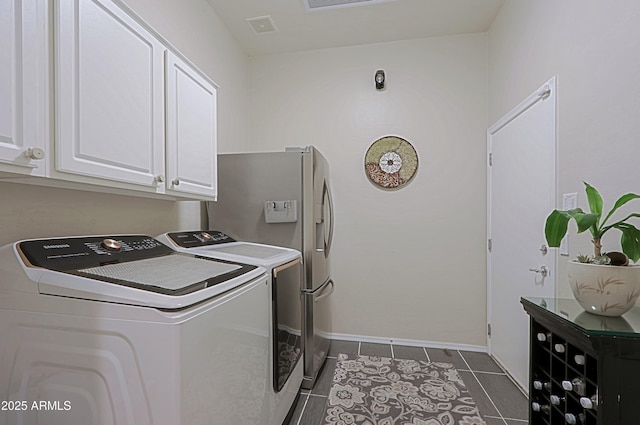 laundry area with baseboards, visible vents, independent washer and dryer, and cabinet space