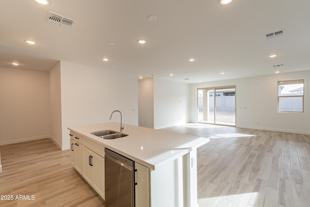21411 W Meadowbrook Ave, Buckeye, AZ 85396 - kitchen with stainless steel dishwasher, light wood-style flooring, a kitchen island with sink, healthy amount of natural light, and recessed lighting