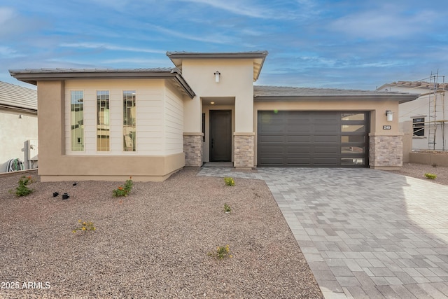 21411 W Meadowbrook Ave, Buckeye, AZ 85396 - prairie-style home with decorative driveway, a garage, stucco siding, and stone siding