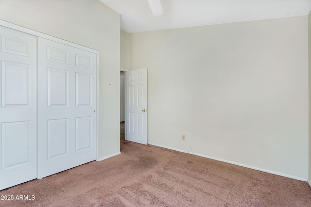 unfurnished bedroom with carpet floors, baseboards, a closet, and ceiling fan